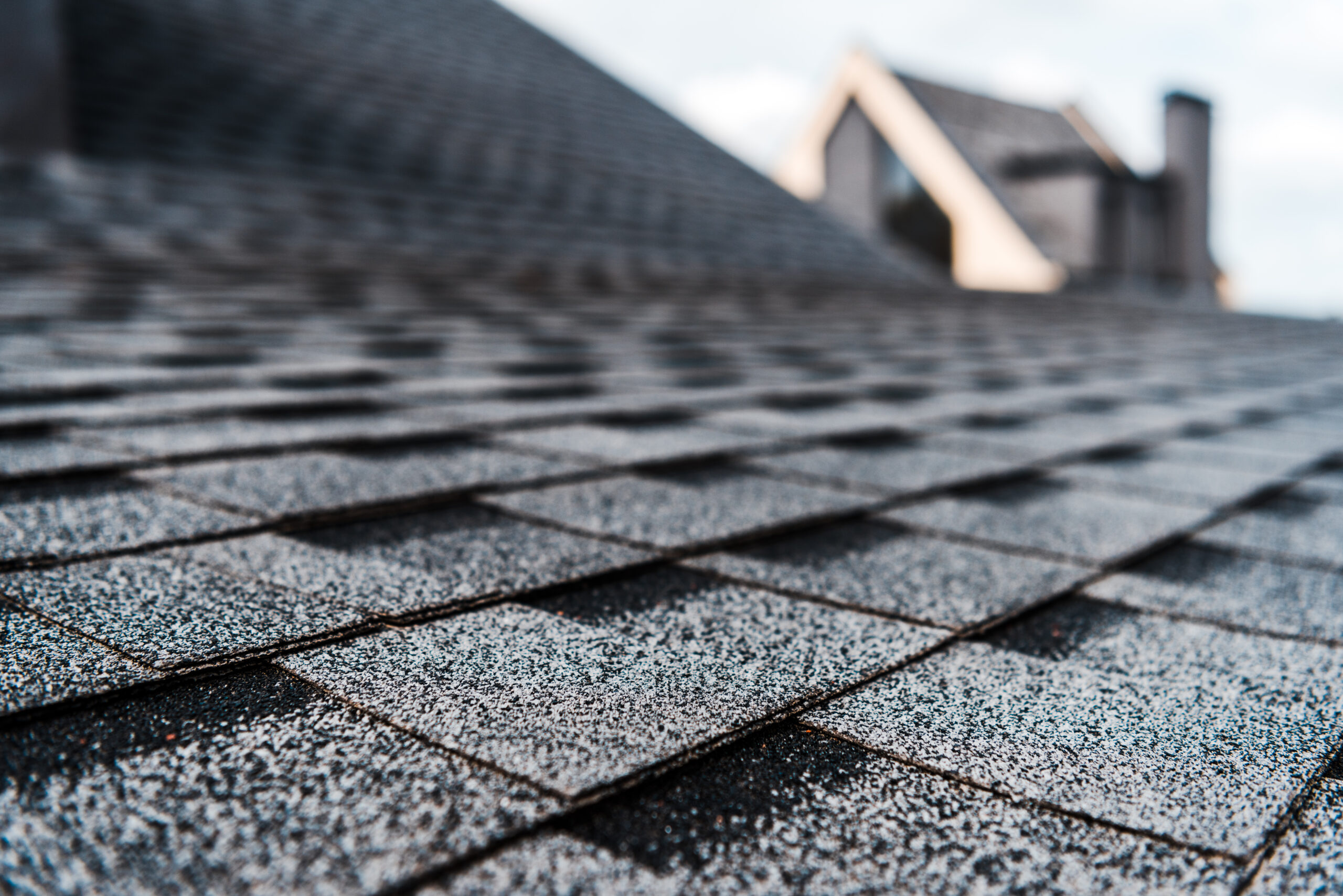 Selective focus of grey shingles on a rooftop, highlighting emergency tarping Jacksonville FL services.