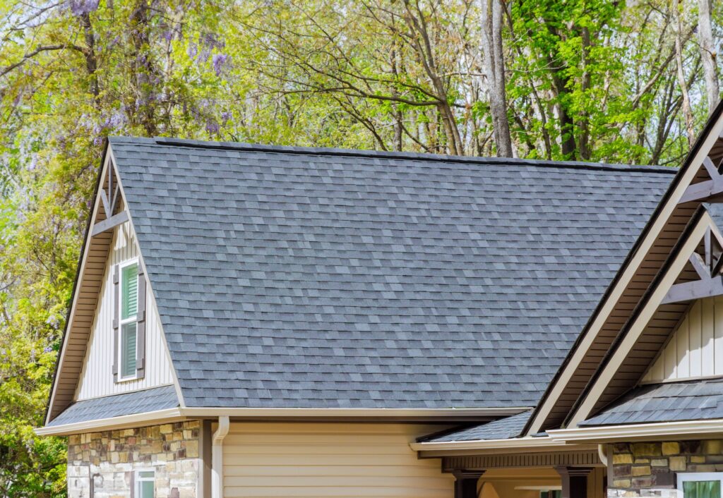 Asphalt shingles on a roof, showcasing roofing services Jacksonville FL, with a clear blue sky in the background.
